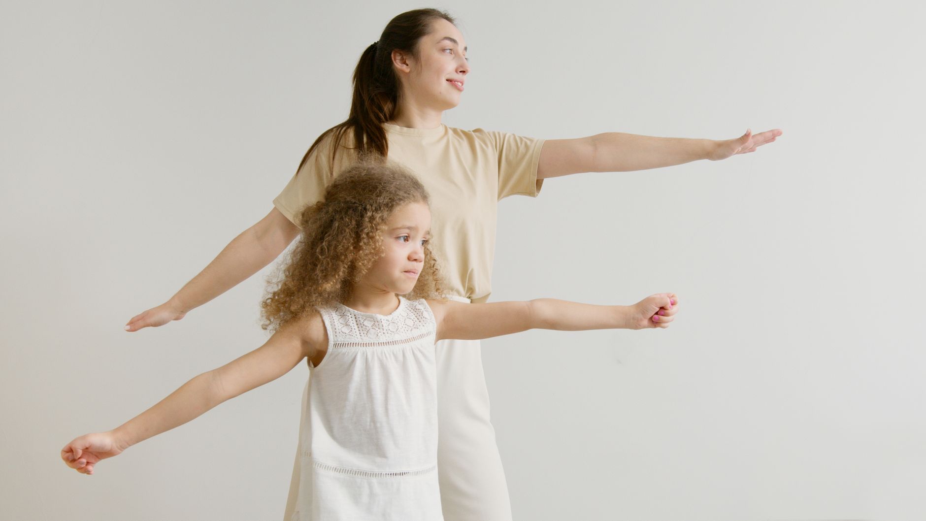 A mother and daughter doing stretching exercises indoors, showcasing family fitness and bonding.